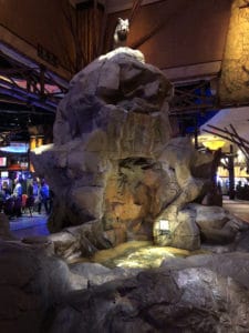 A large faux rock display with a wolf sculpture representing the Mohegan tribe. 