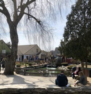 Spectators watch the duck pond at Olde Mistick Village on a sunny day. 