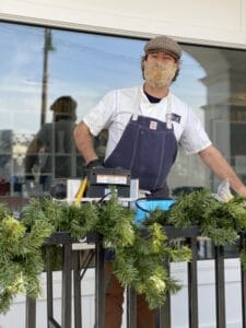 man wearing a face mask while supporting our local community and serving hot chocolate outside in in stonington, ct.