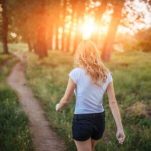 Woman walking in nature at sunset